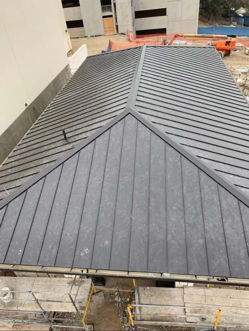 Commercial metal roof construction with crane equipment in Lawrence